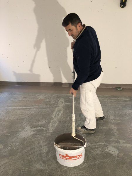 Mann trägt Bodenversiegelung