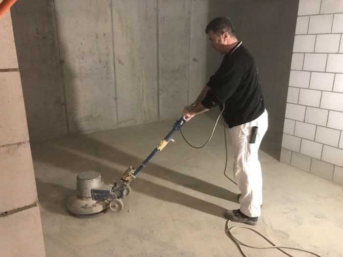 Mann poliert Sichtestrichboden