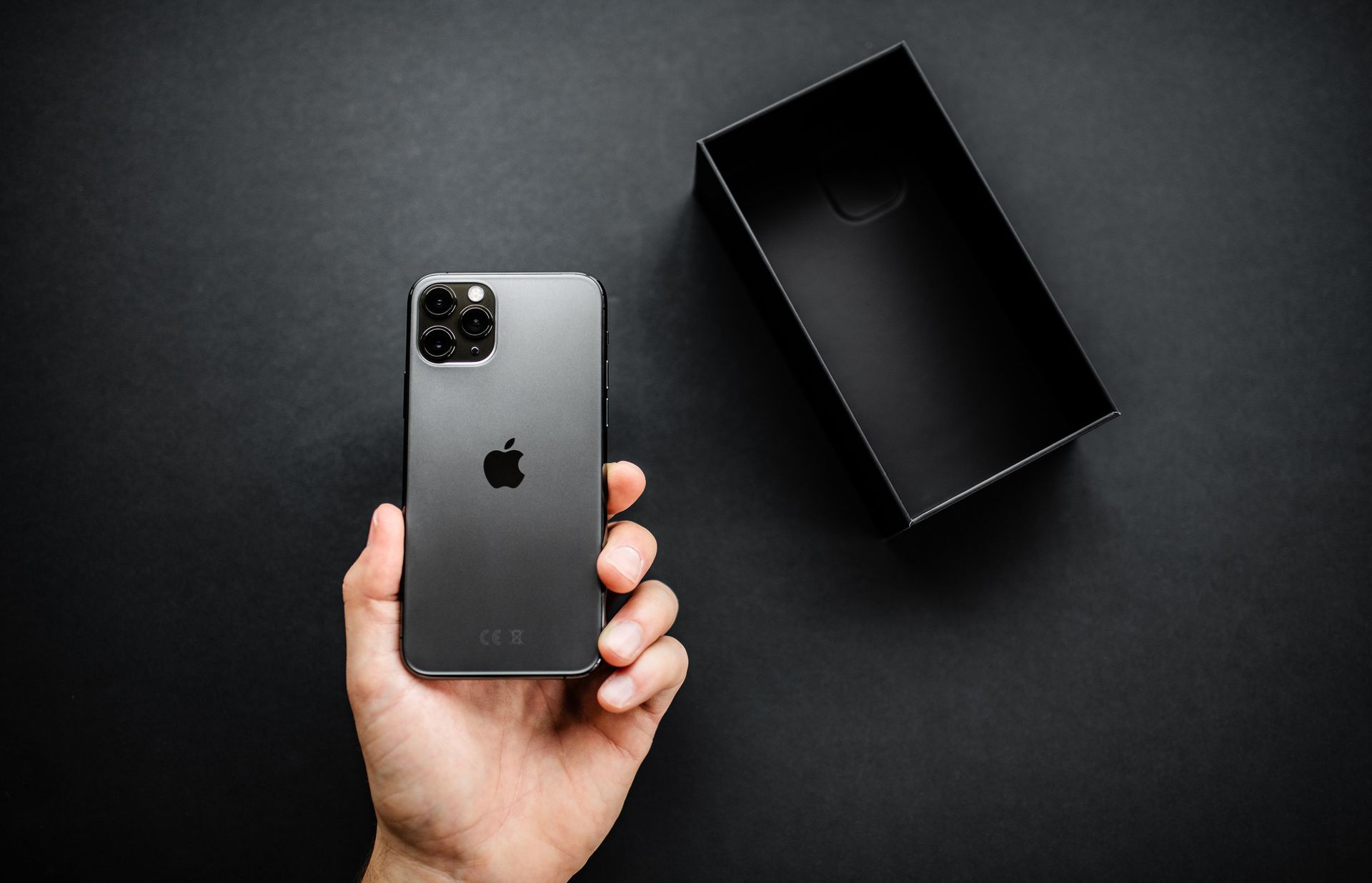 Una persona sostiene un iPhone negro en su mano.