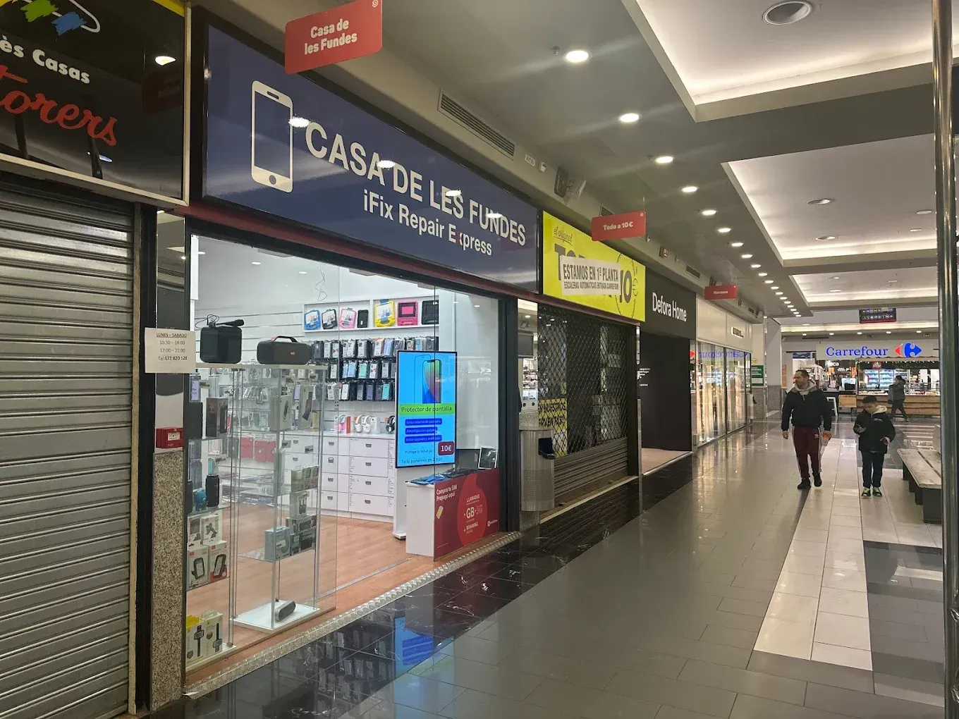 Una fila de tiendas están alineadas en un centro comercial.
