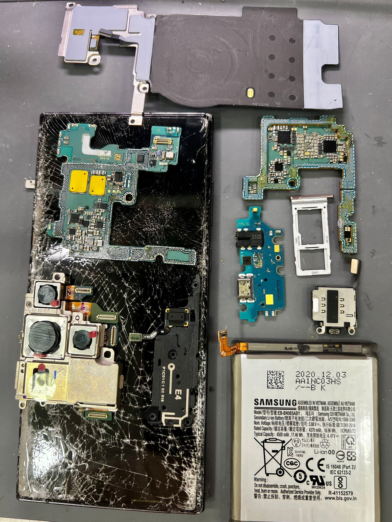 Se está reparando un teléfono celular con pinzas y tijeras.