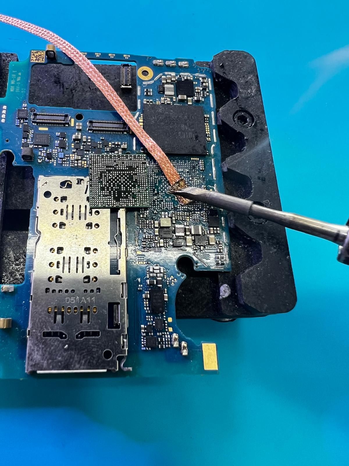Una persona está soldando una placa de circuito con un soldador.