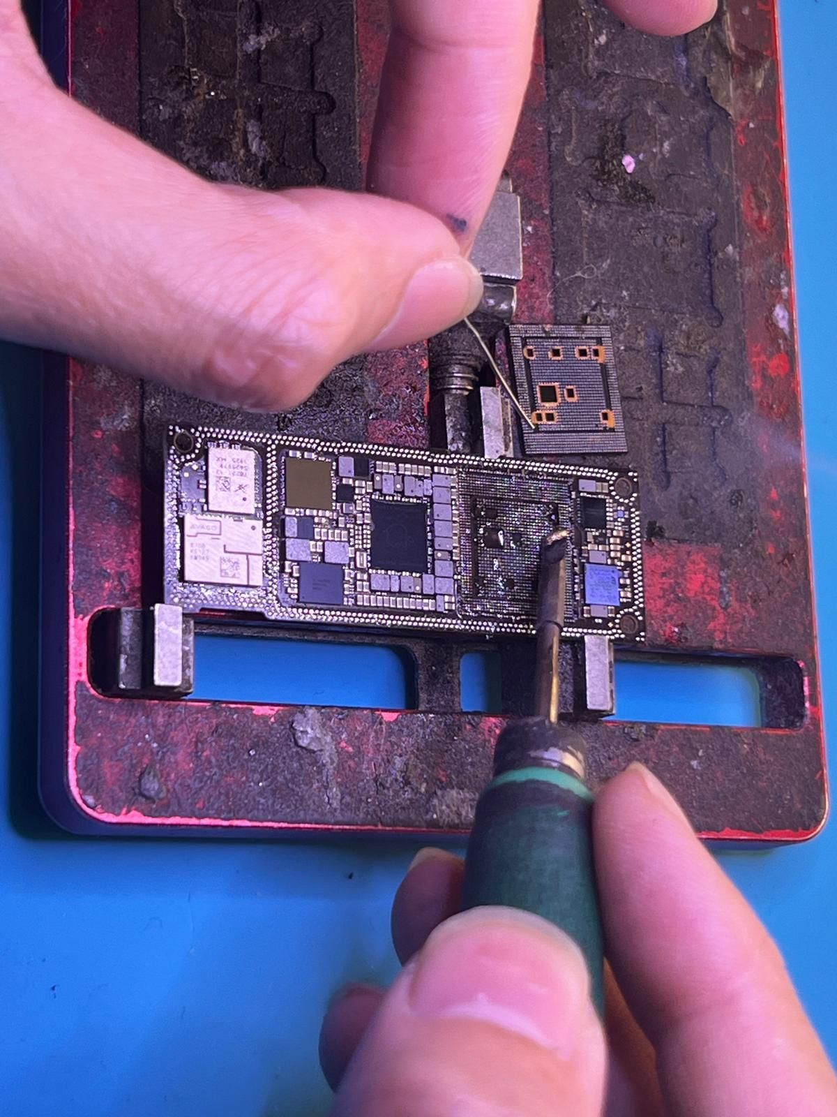 Se están reparando dos teléfonos celulares con herramientas sobre una mesa.