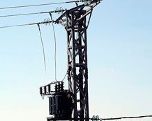 Un poste telefónico con un transformador encima.