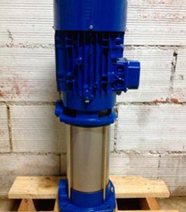 Una bomba de agua azul está colocada encima de una paleta de madera.