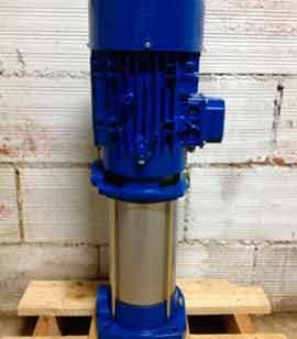 Una bomba de agua azul está colocada encima de una paleta de madera.