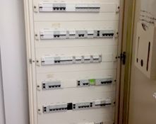 Una caja eléctrica blanca con mucho equipo eléctrico dentro.