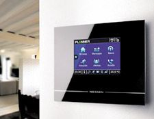 Un monitor de pantalla táctil en blanco y negro está montado en una pared en una sala de estar.