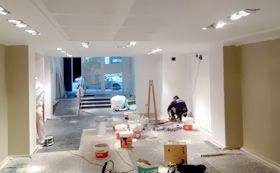 Un hombre está pintando una habitación en un edificio.