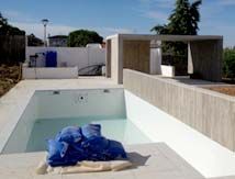 Se está construyendo una piscina en el patio trasero de una casa.