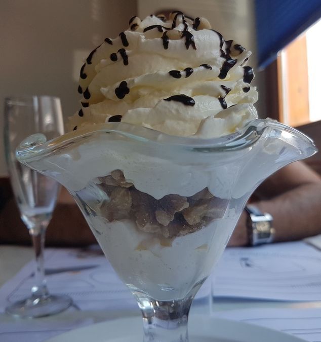 Un primer plano de un helado con crema batida y chispas de chocolate.