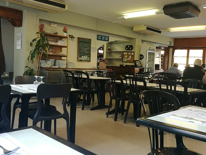 Un restaurante con mesas y sillas y un cartel que dice 'a' en él
