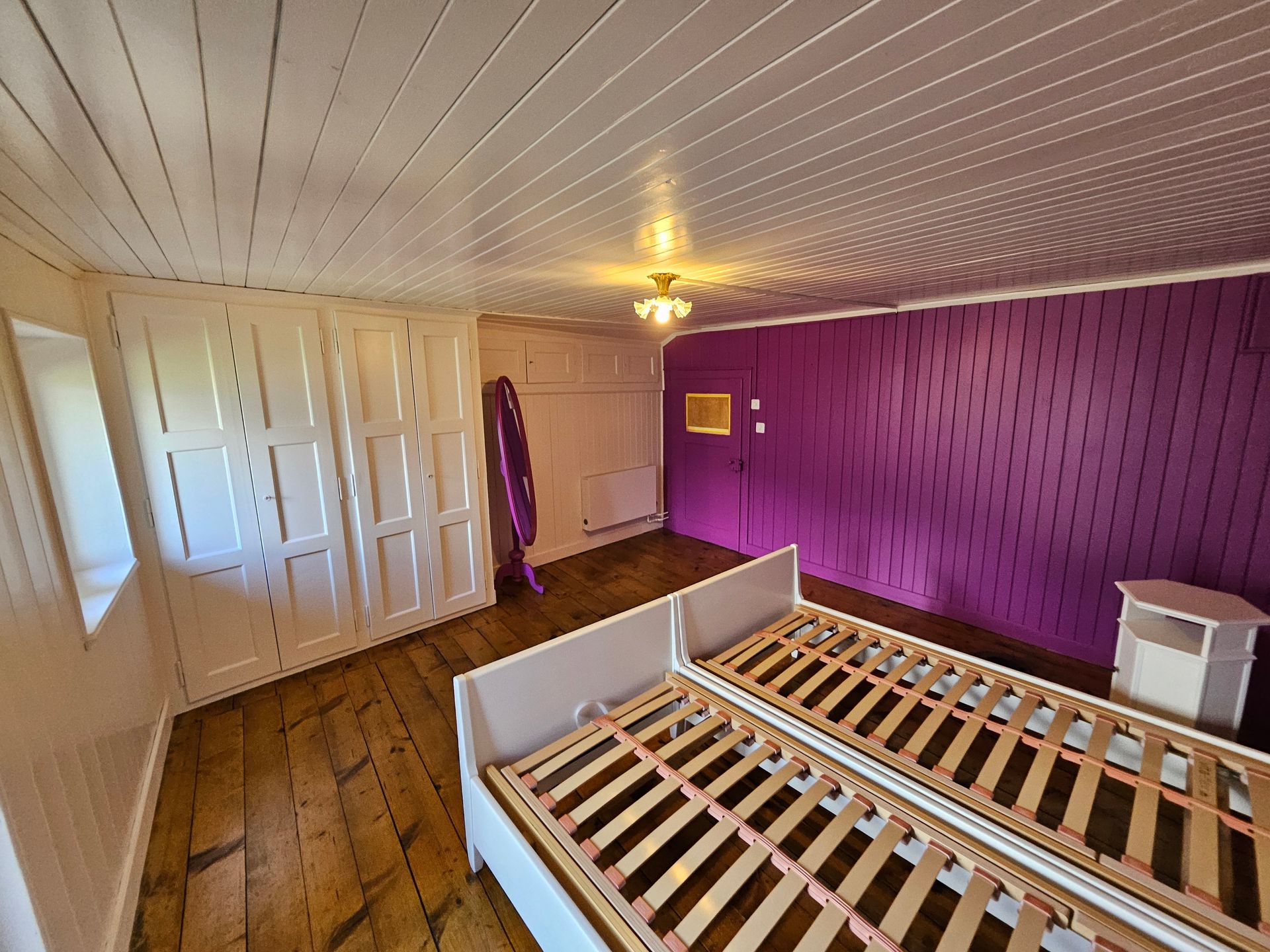 Une caravane jaune avec des finitions blanches et une voiture bleue garée à côté.