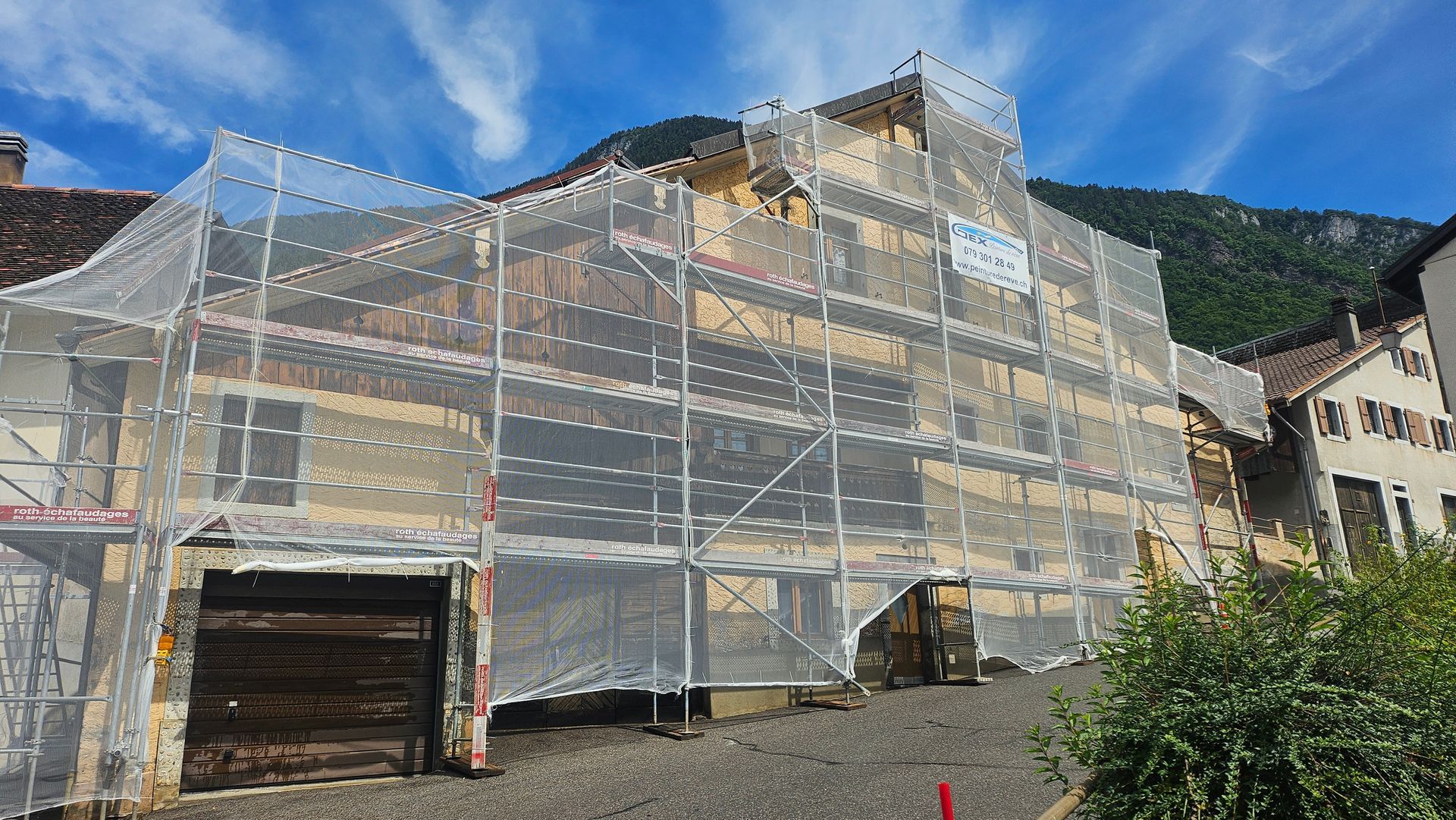 Pièce avec parquet, murs peints, fenêtre, échelle et matériel de peinture.