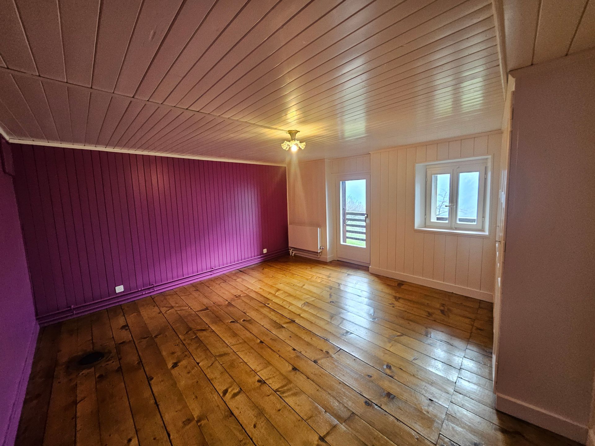 Rénovation d'une colonne : Colonne en pierre partiellement recouverte de ciment, avec cour et bâtiment en arrière-plan.