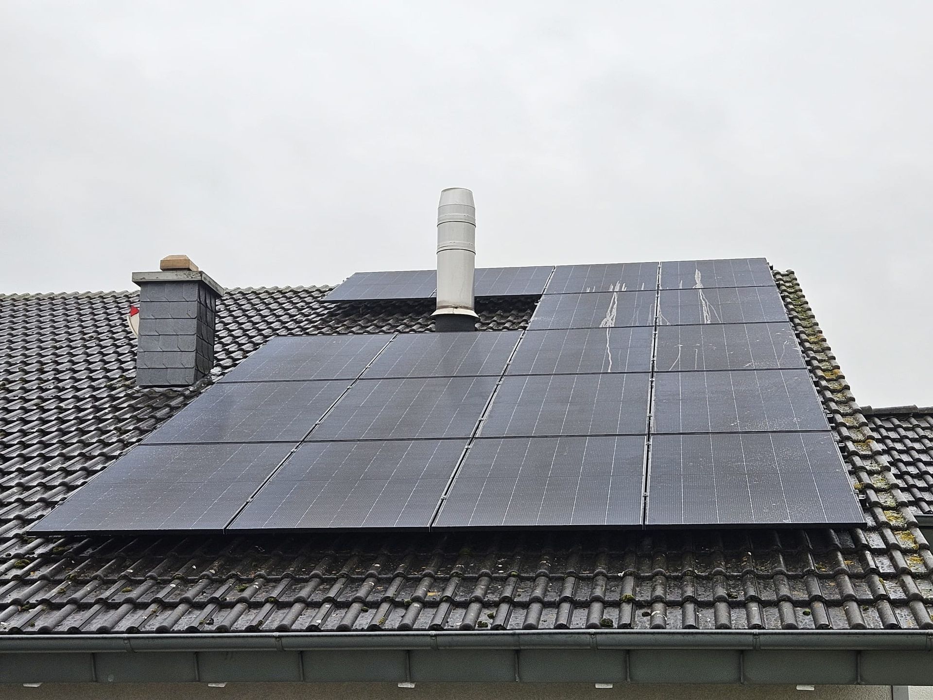 Auf dem Dach eines Hauses befinden sich viele Solarmodule.