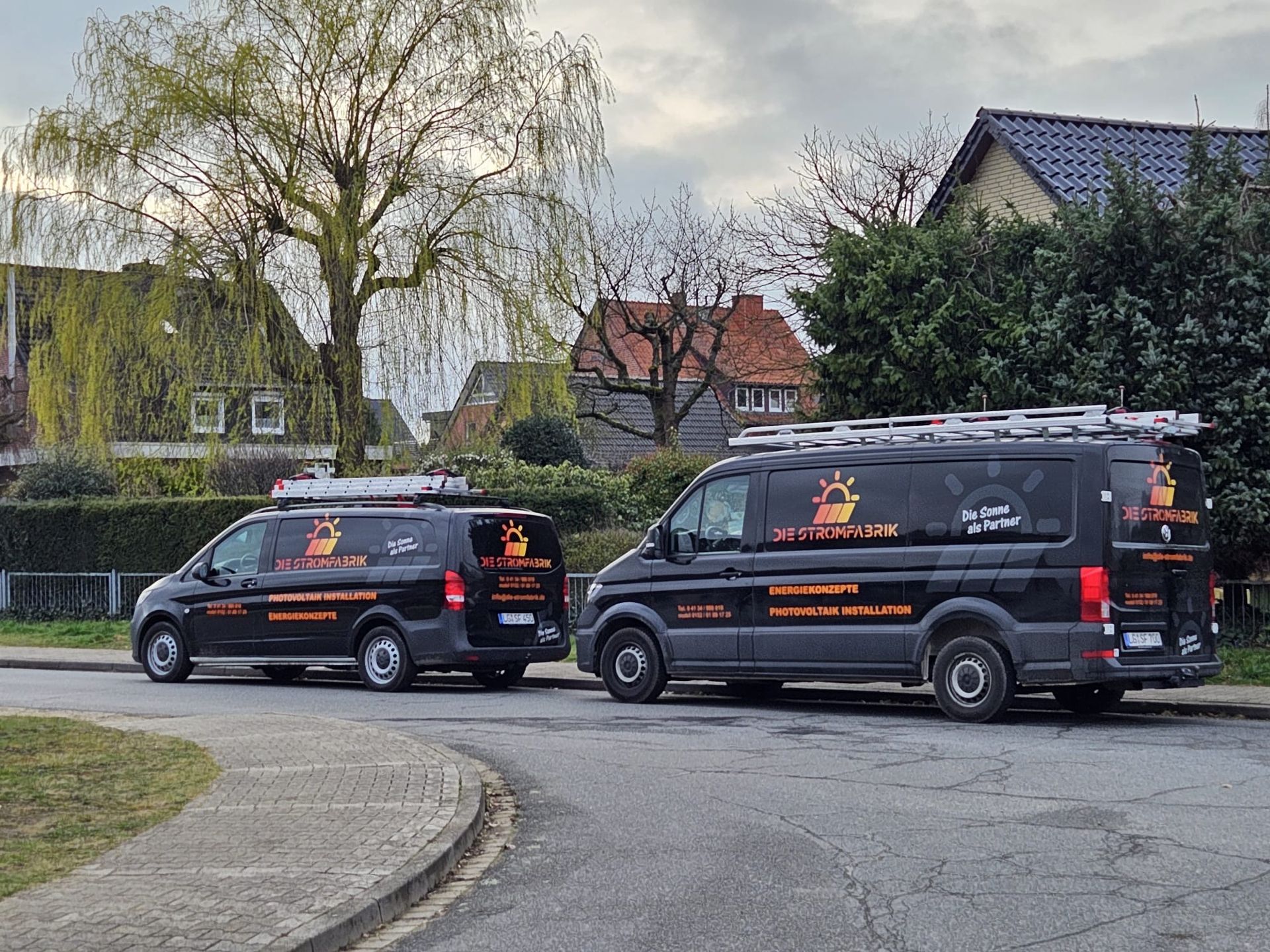Zwei schwarze Lieferwagen parken am Straßenrand.