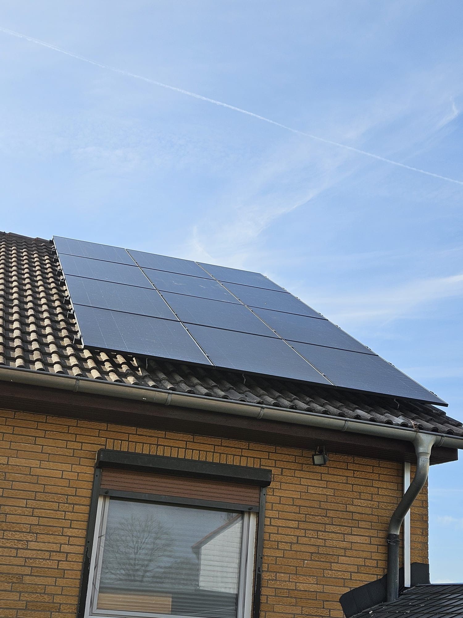 Ein Backsteinhaus mit Sonnenkollektoren auf dem Dach