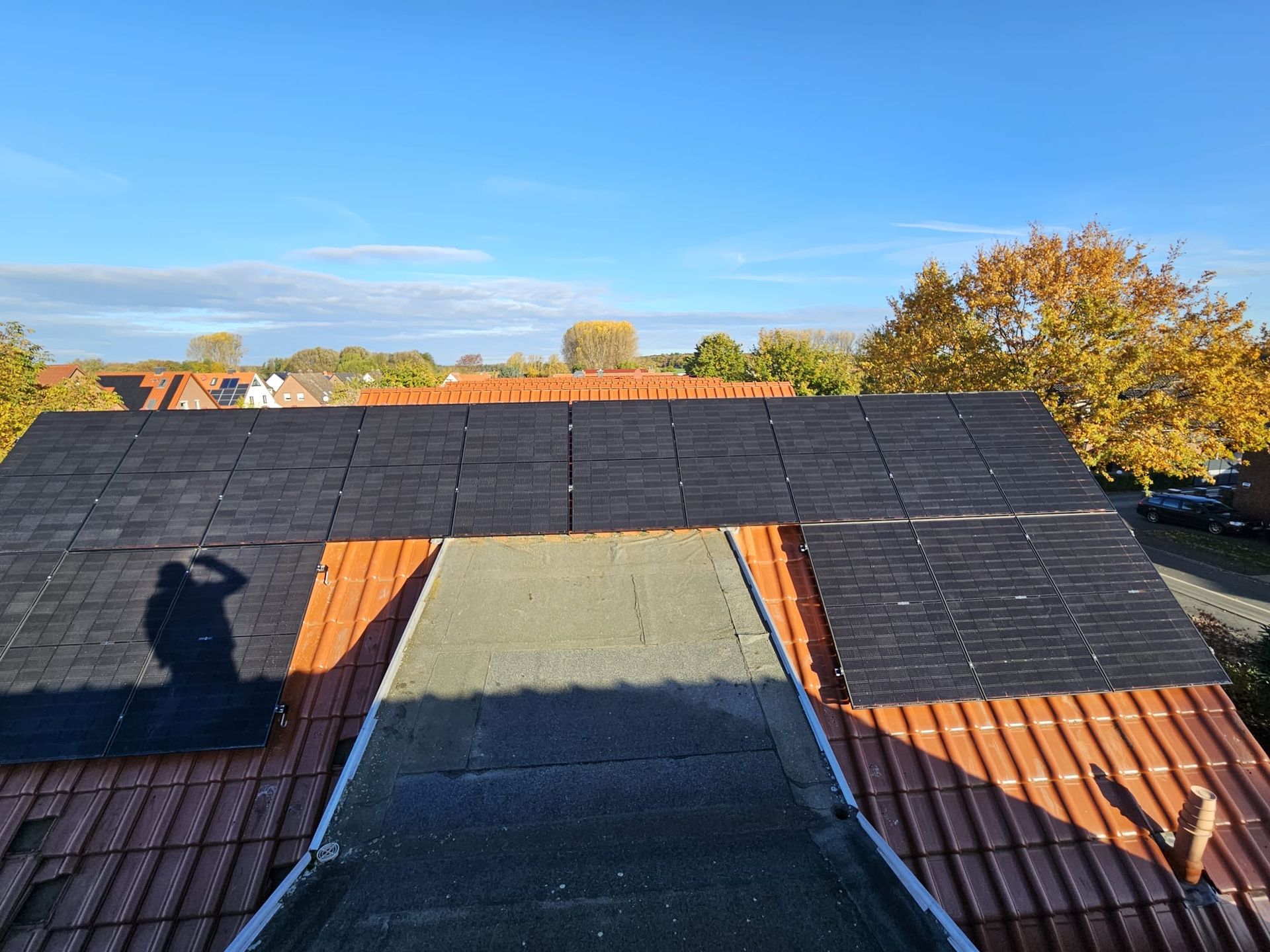 Der Schatten einer Person wird auf das Dach eines Gebäudes geworfen.