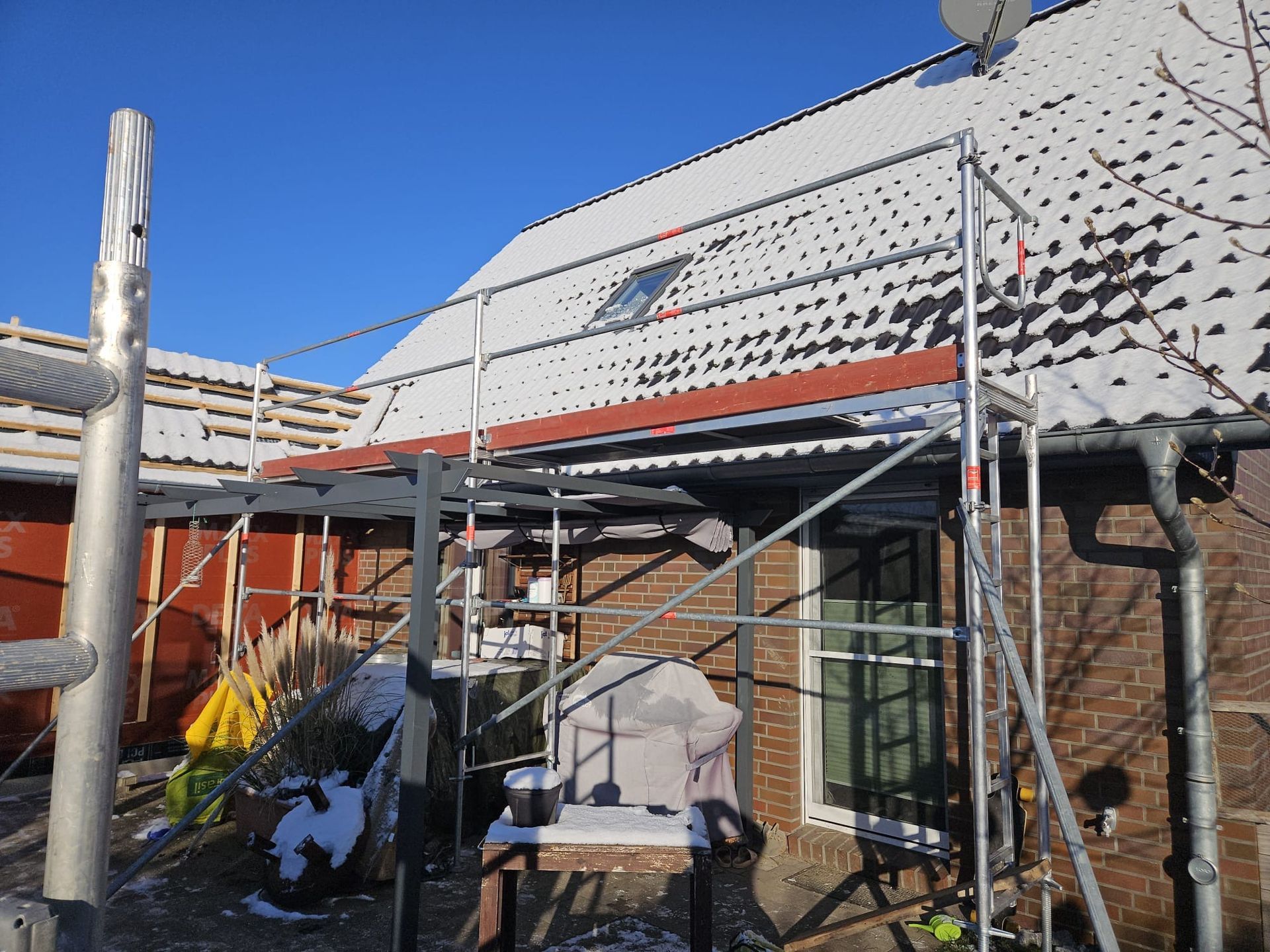 Ein Backsteinhaus mit Gerüst an der Seite