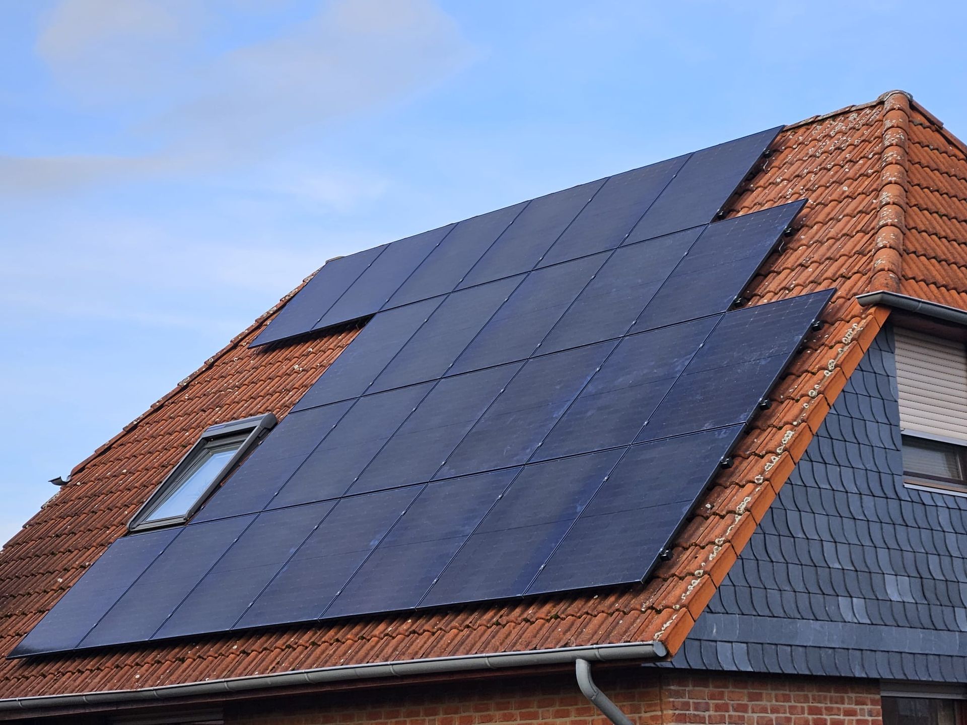 Ein Backsteinhaus mit Sonnenkollektoren auf dem Dach