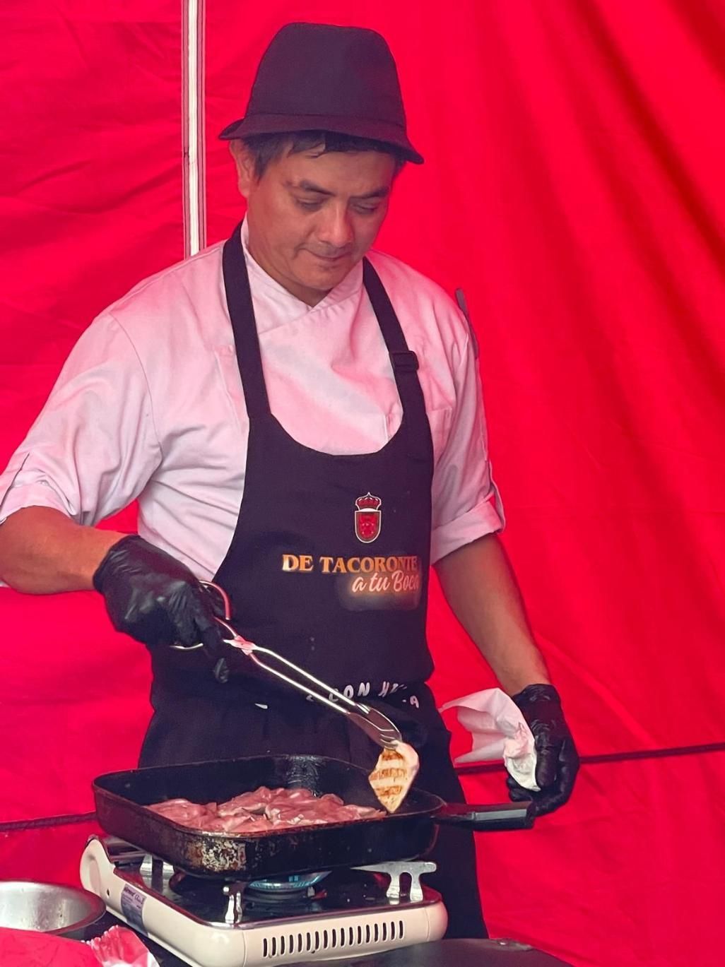 Un plato blanco rectangular con carnes asadas: cerdo y un plato de verduras, adornado con hierbas.