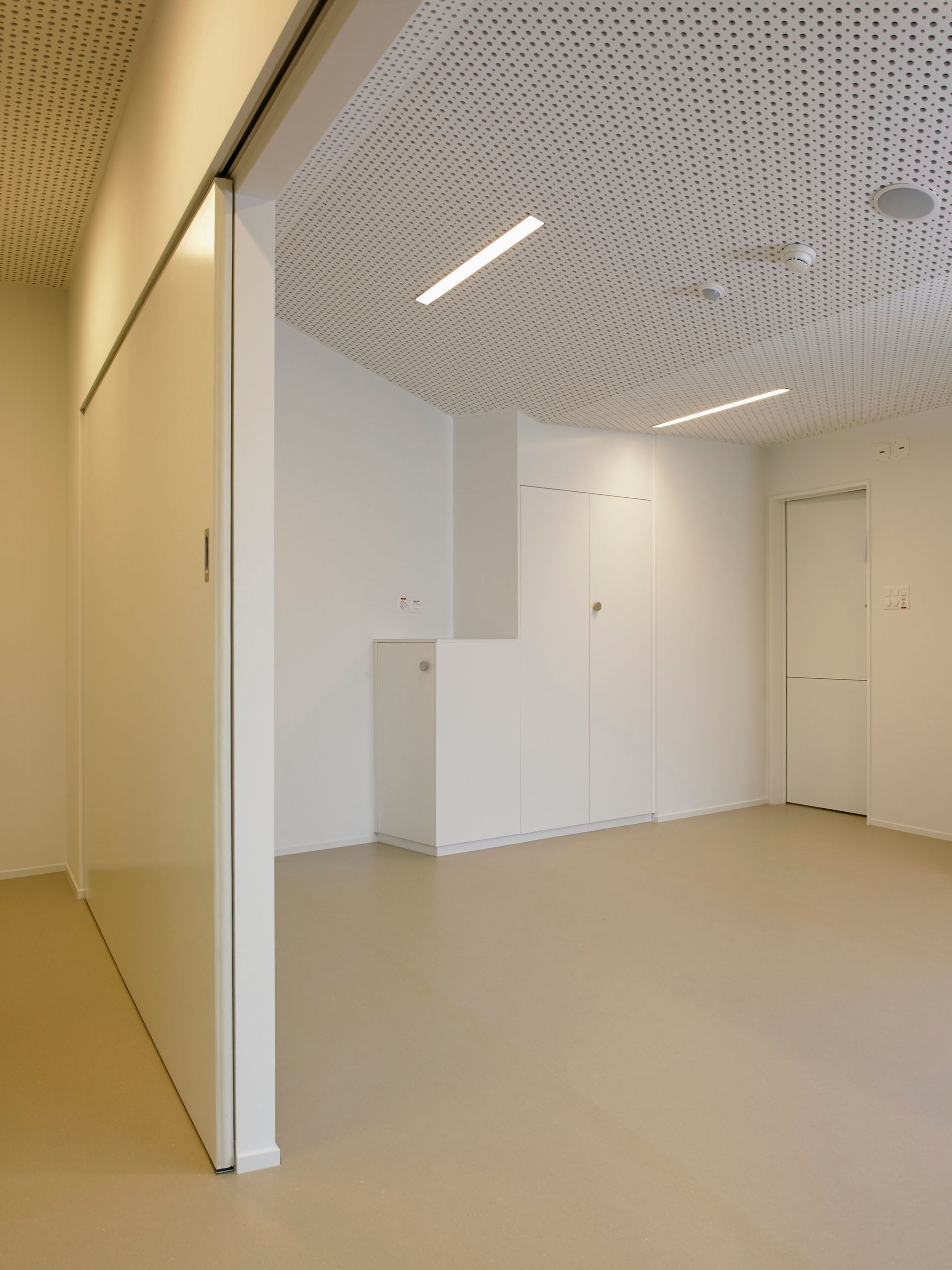Une pièce avec une porte coulissante et un plafond avec des trous.