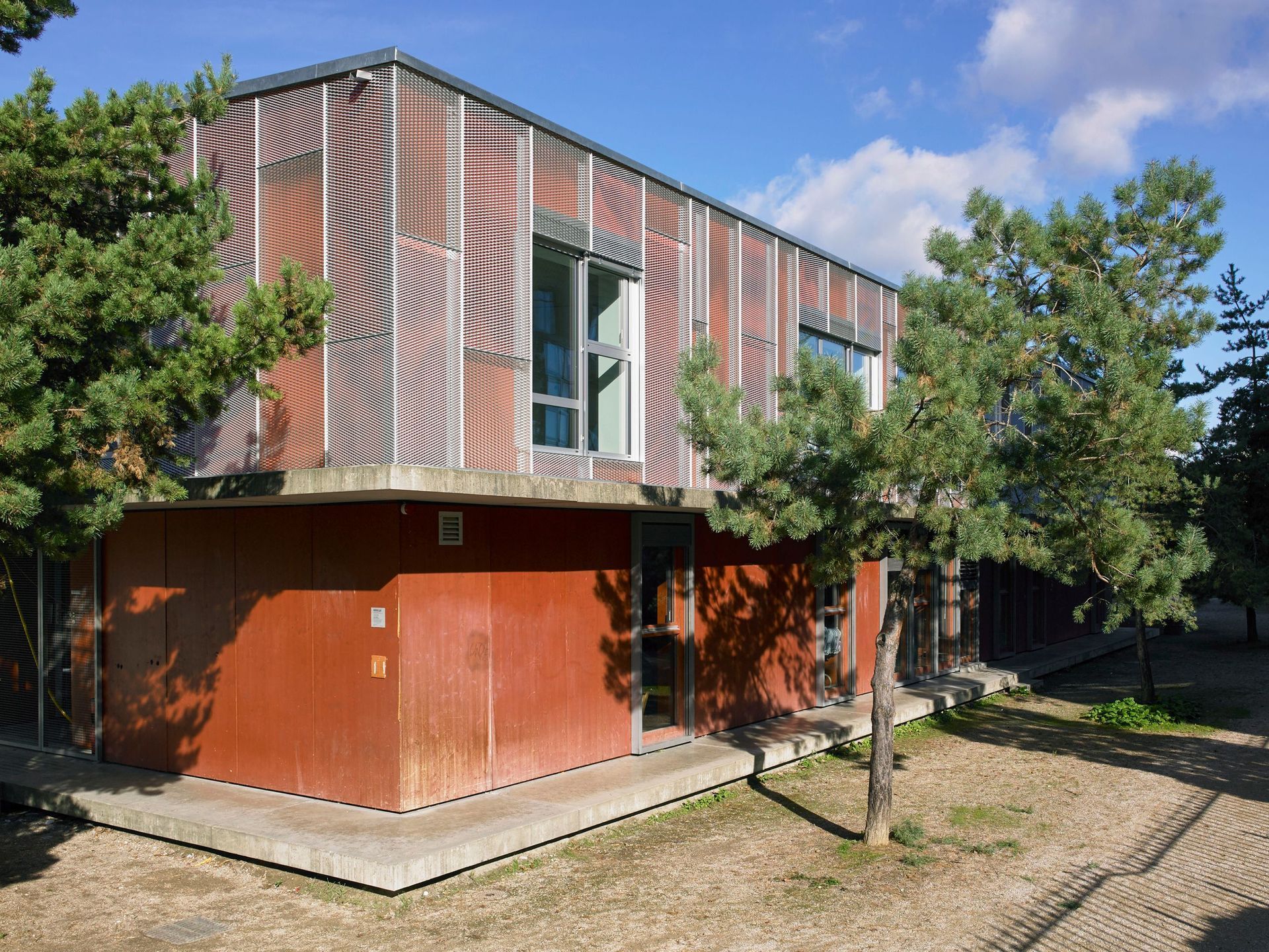 Une grande maison avec une terrasse en bois et un arbre devant.