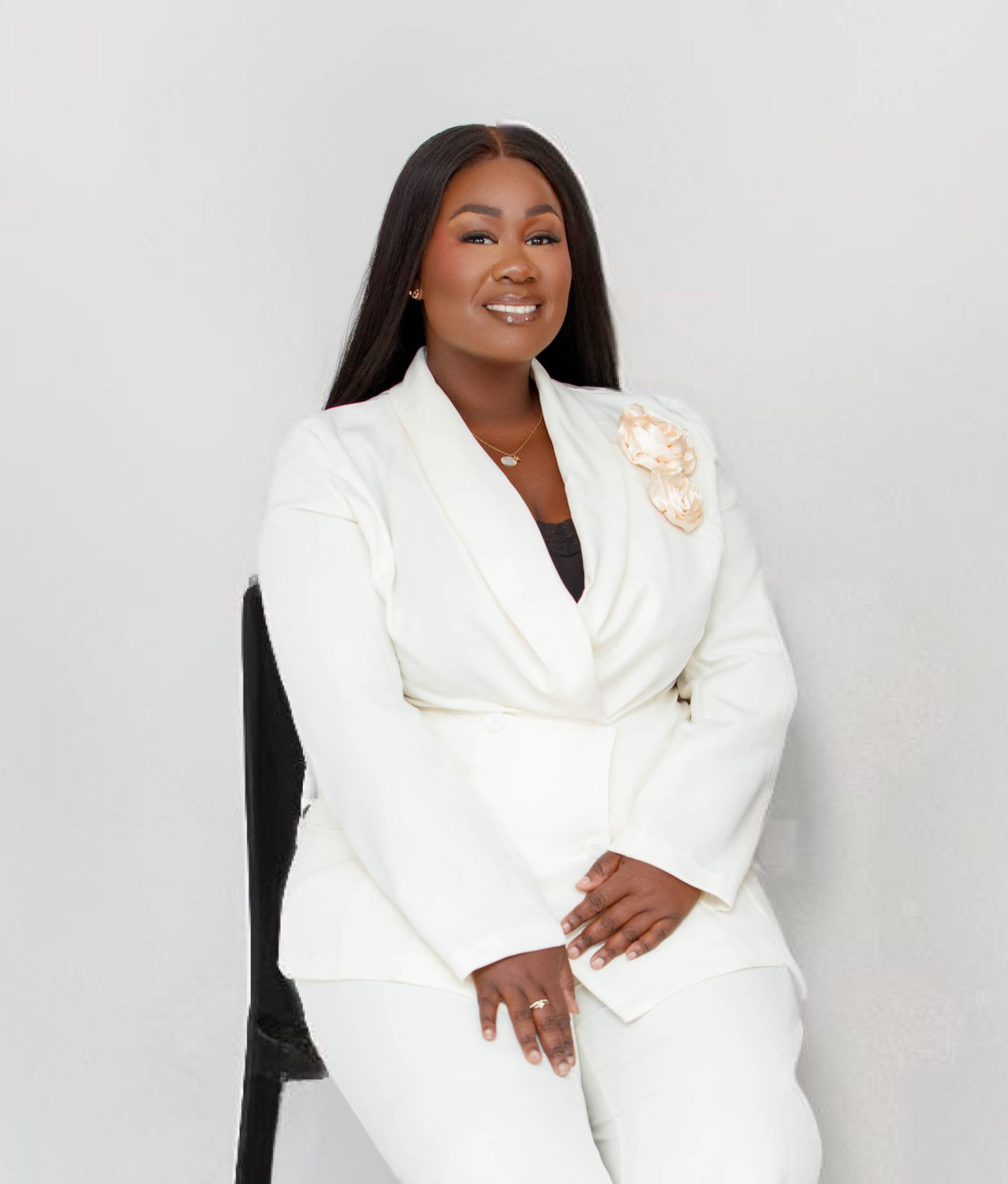 Femme en robe blanche, regardant ailleurs, avec un décolleté orné, sur fond blanc.