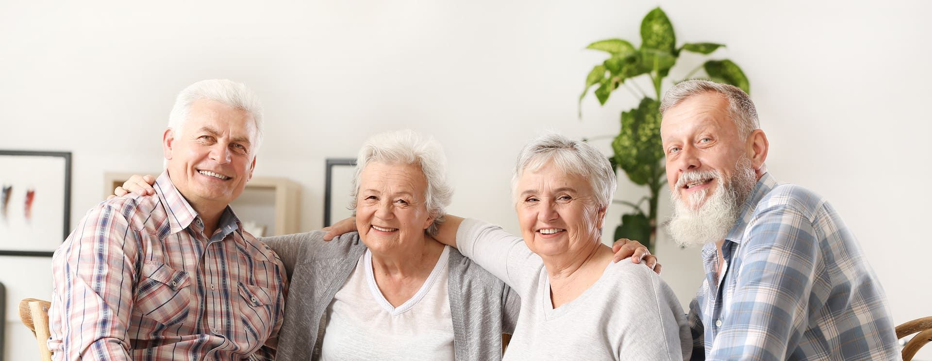 Vier ältere Menschen posieren für ein Foto und lächeln | St. Brigida Seniorenzentrum