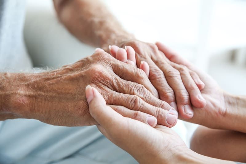 Eine Frau hält die Hände eines älteren Mannes | St. Brigida Seniorenzentrum
