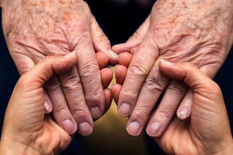 Eine junge Frau hält die Hände eines älteren Mannes | St. Brigida Seniorenzentrum