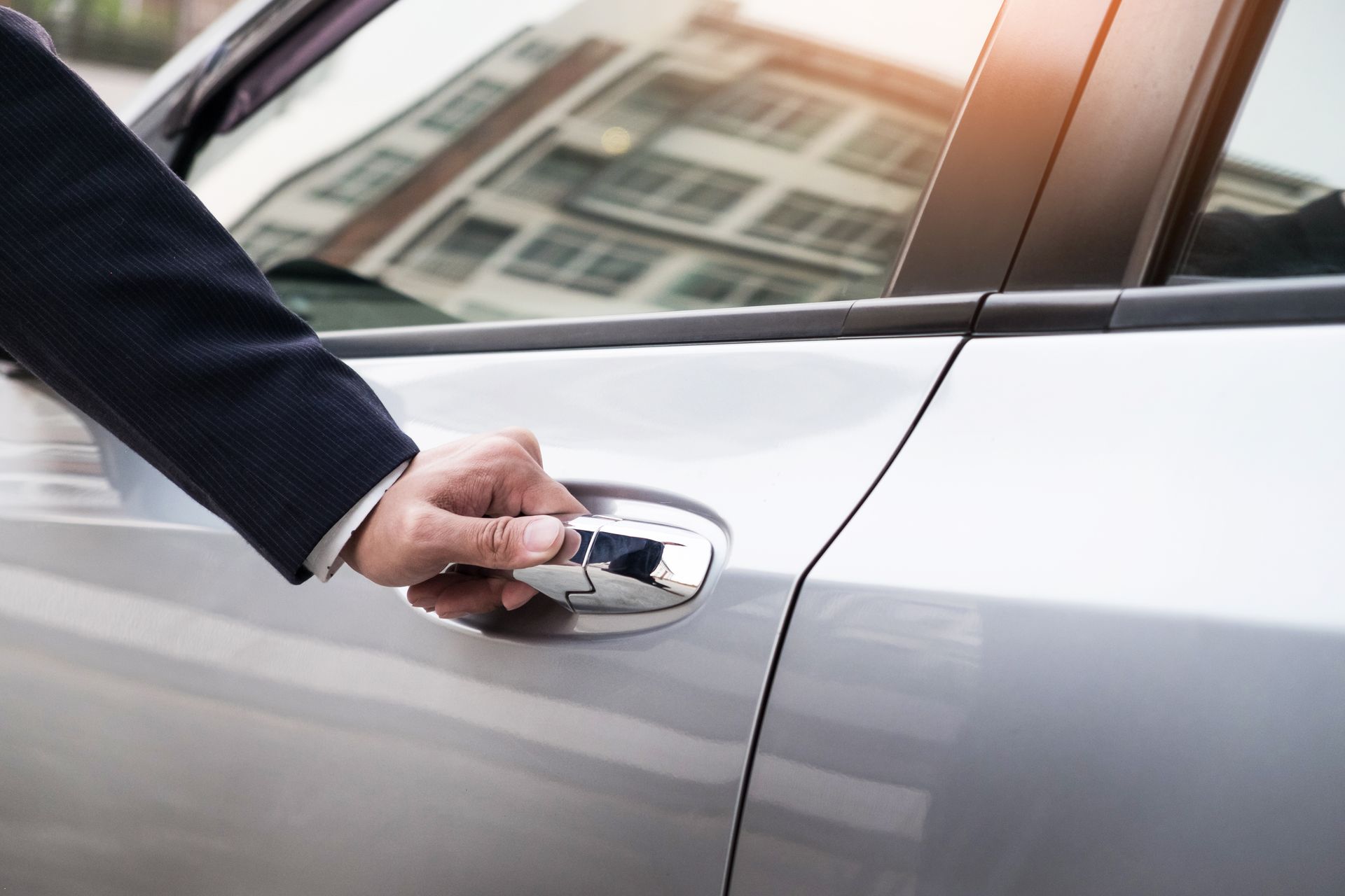 Main d'une personne ouvrant la porte d'une voiture