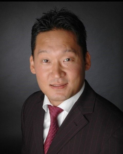 Ein Mann in Anzug und Krawatte lächelt in die Kamera