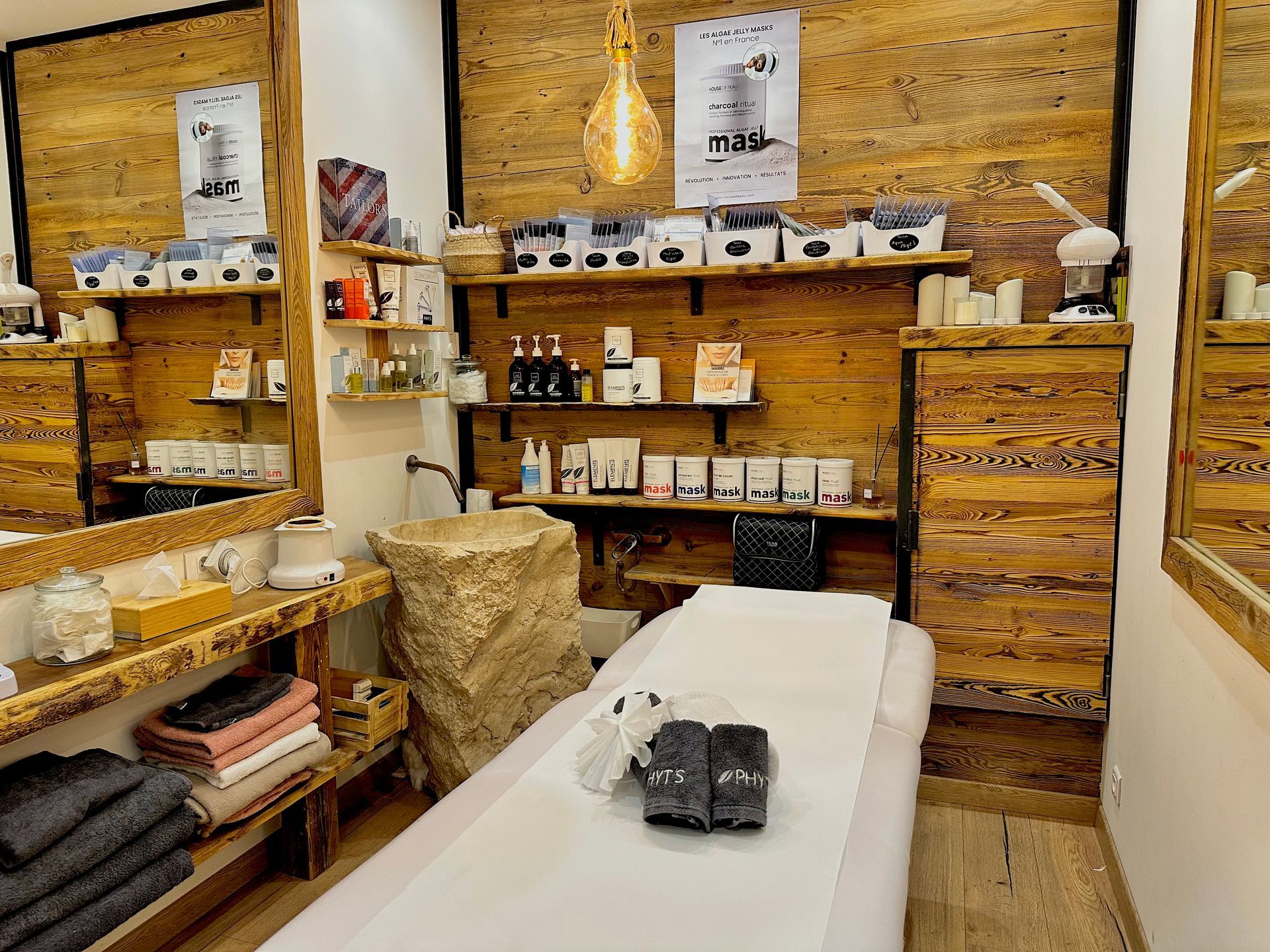 Espace de soin avec des étagères en bois et une table de massage