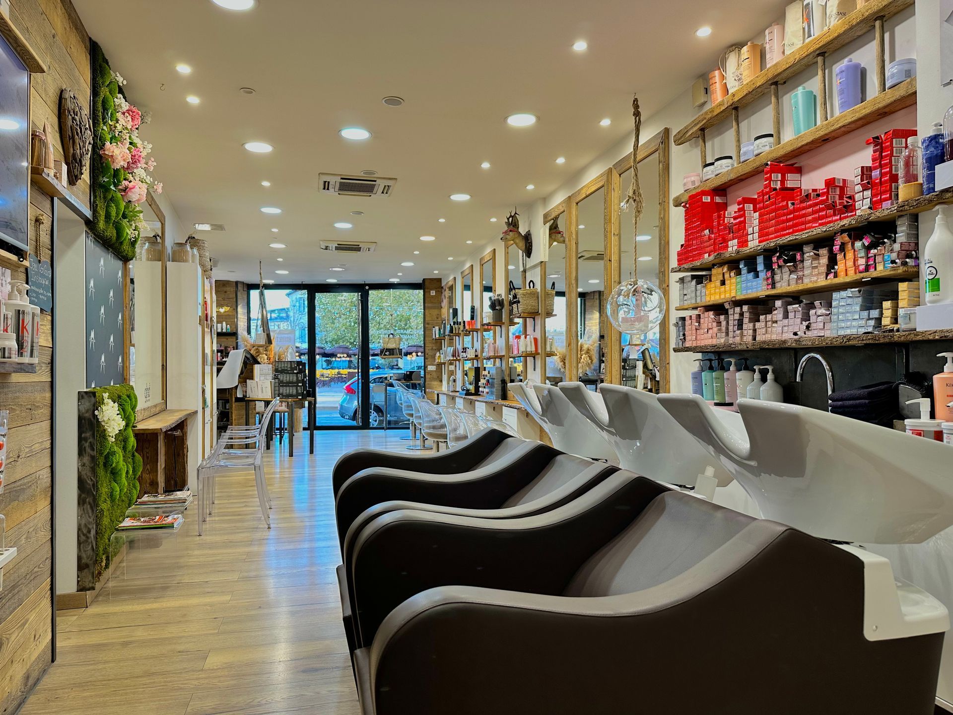Intérieur de salon de coiffure moderne avec fauteuils noirs, étagères de produits et portes vitrées à l'arrière