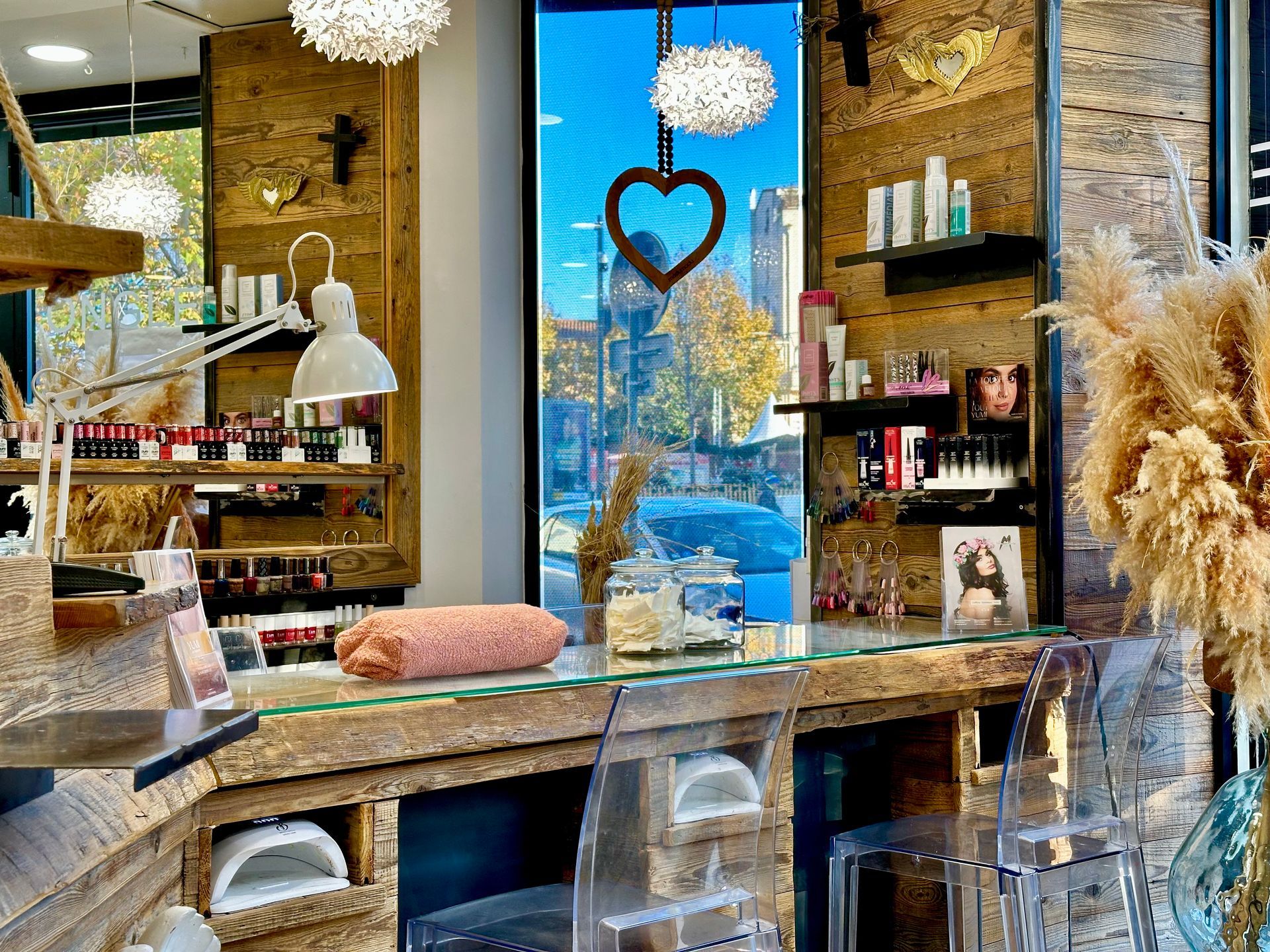 Comptoir chaleureux avec des étagères, des fleurs séchées et une décoration suspendue en forme de cœur près d'une fenêtre