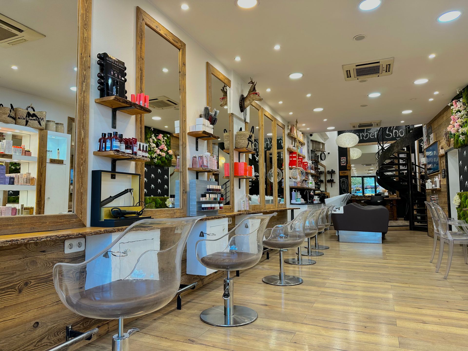 Intérieur moderne d'un salon de coiffure avec fauteuils de coiffure, miroirs, étagères et parquet