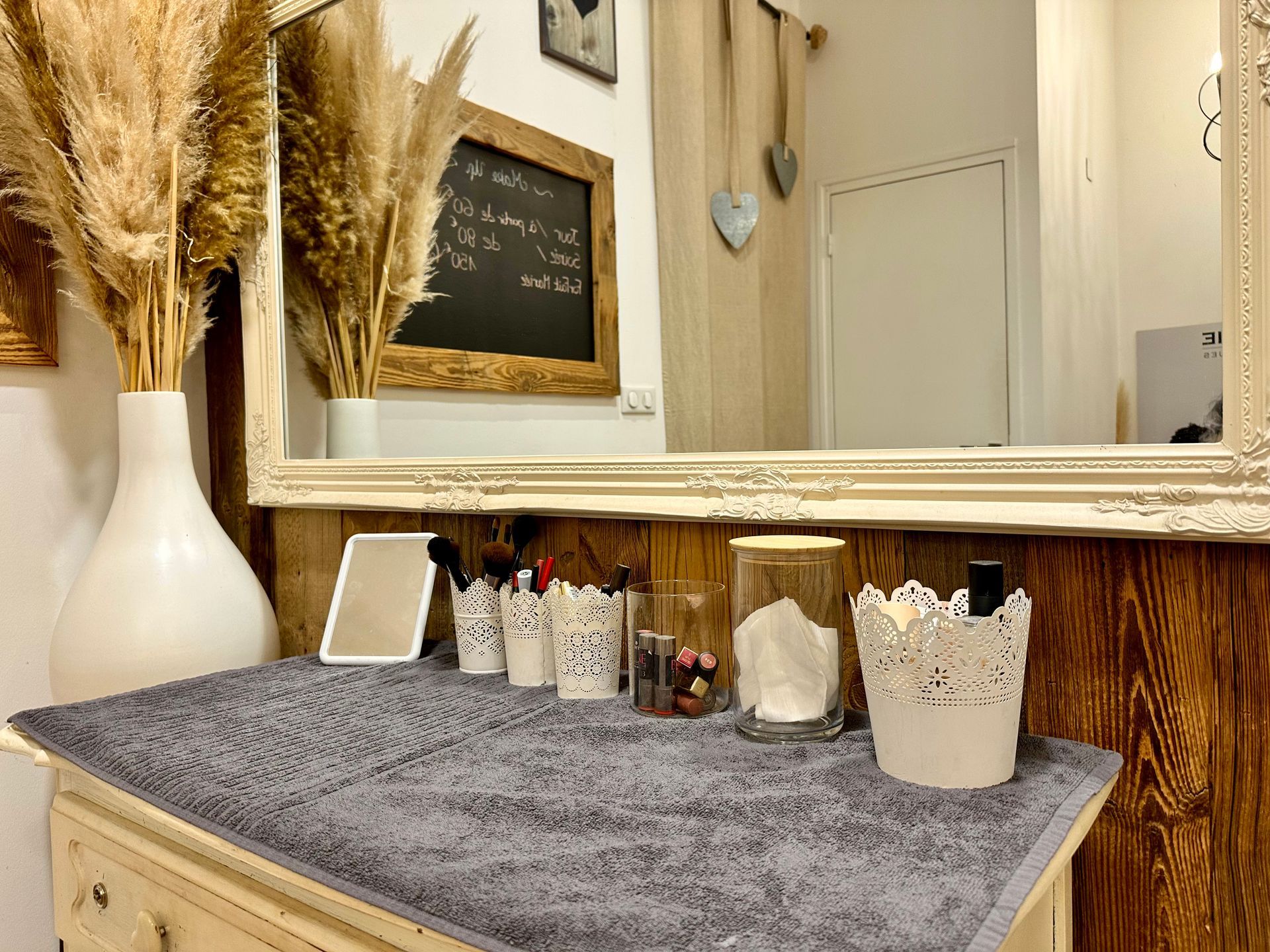 Coiffeuse avec tapis gris, décoration blanche, herbe de la pampa et miroir