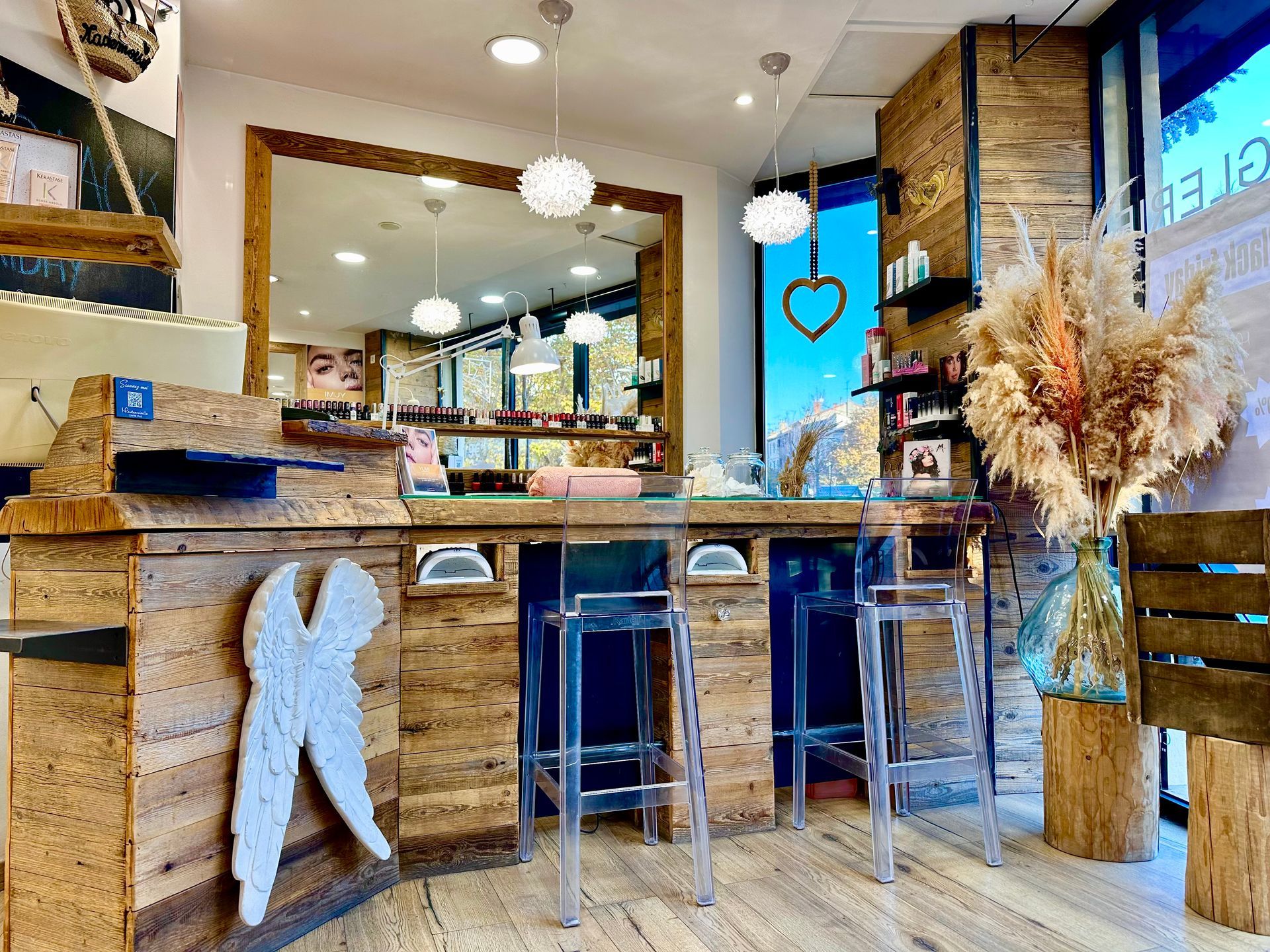 Intérieur de salon de coiffure avec comptoir en bois, tabourets, miroir et suspensions lumineuses
