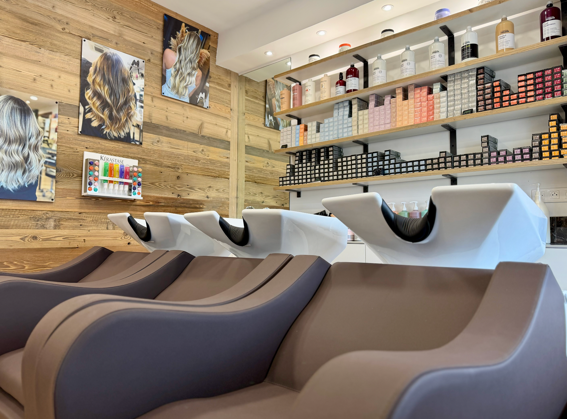Espace shampoing moderne avec trois fauteuils de lavage inclinables, étagères murales et décor en bois
