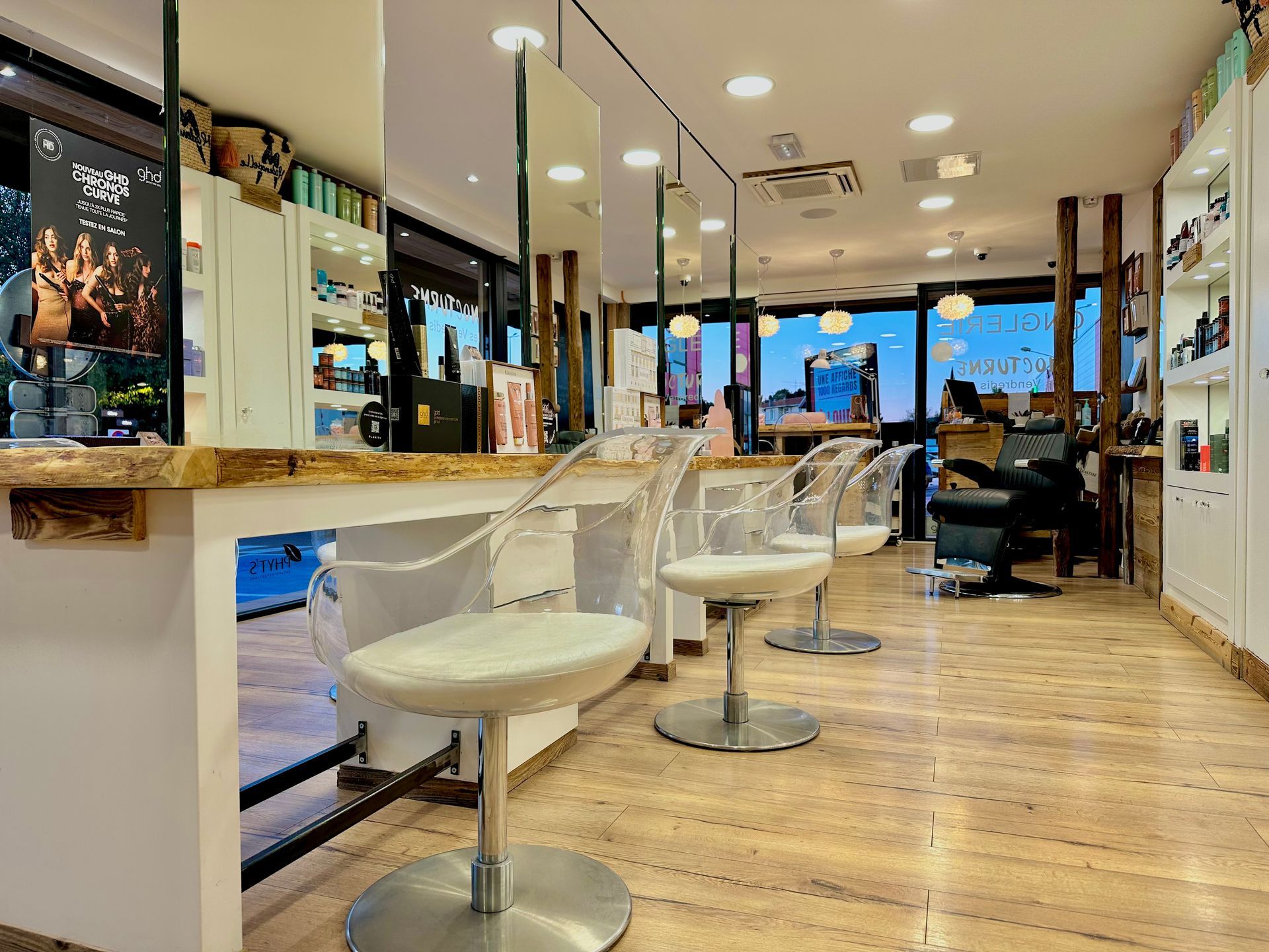 Intérieur de salon de coiffure avec chaises blanches, parquet et grandes fenêtres