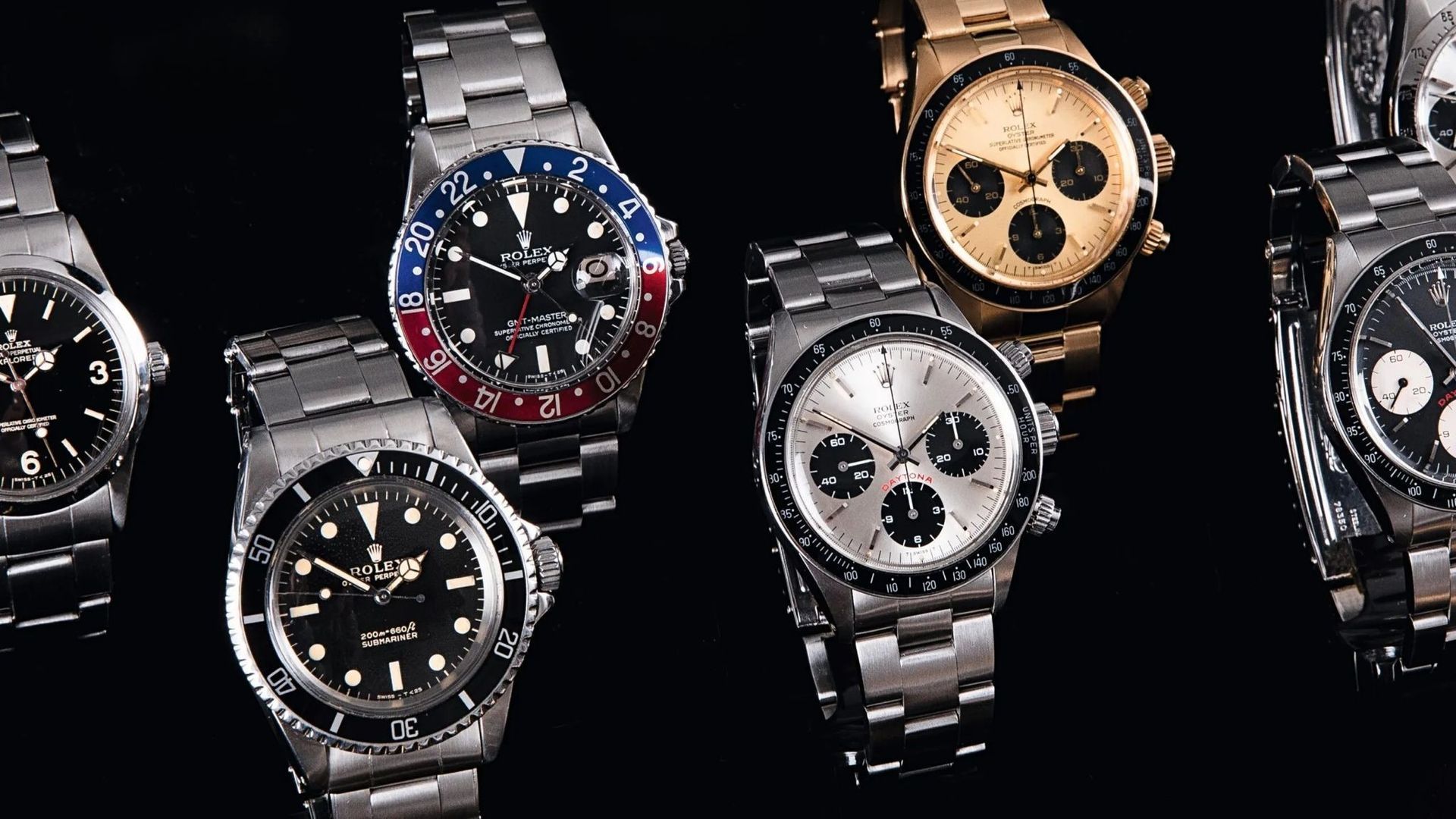Un grupo de relojes están colocados uno al lado del otro sobre un fondo negro.