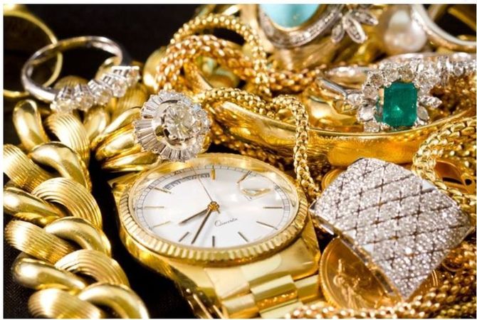 Una pila de joyas de oro que incluían un reloj y anillos.