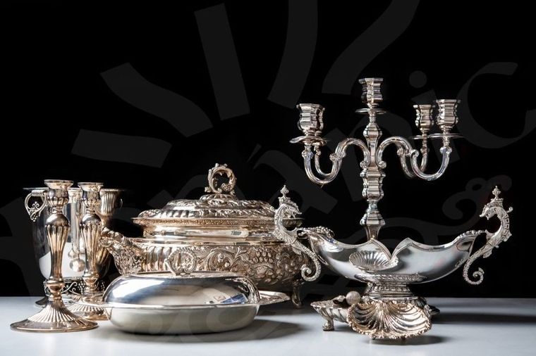 Un grupo de artículos de plata que incluye un candelabro y un cuenco.