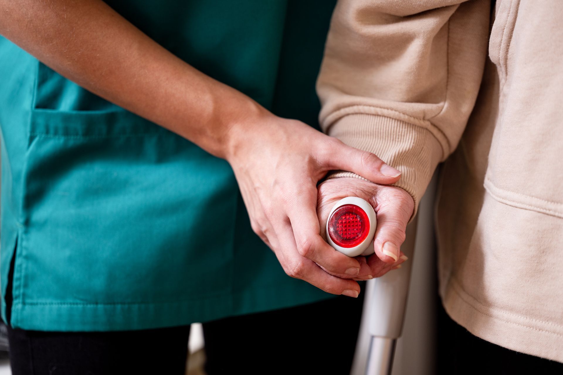 Eine Krankenschwester hält die Hand einer älteren Frau, die Krücken benutzt.