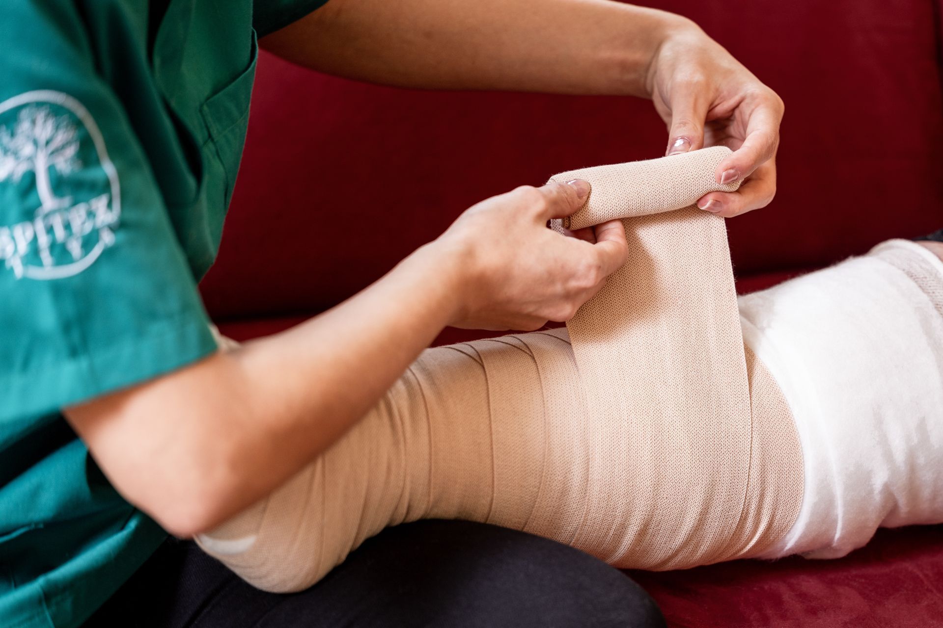 Eine Person umwickelt ein Bein mit einem Verband.