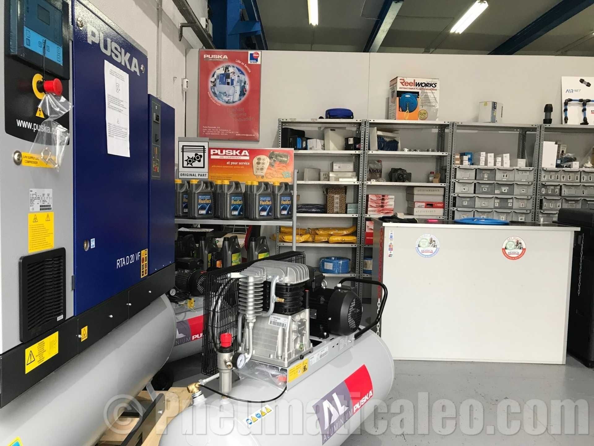 Un gran compresor de aire está en una habitación con estantes.