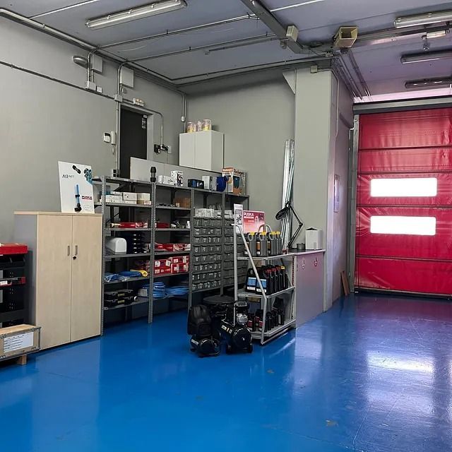 Un garaje con suelos azules y una puerta de garaje roja.