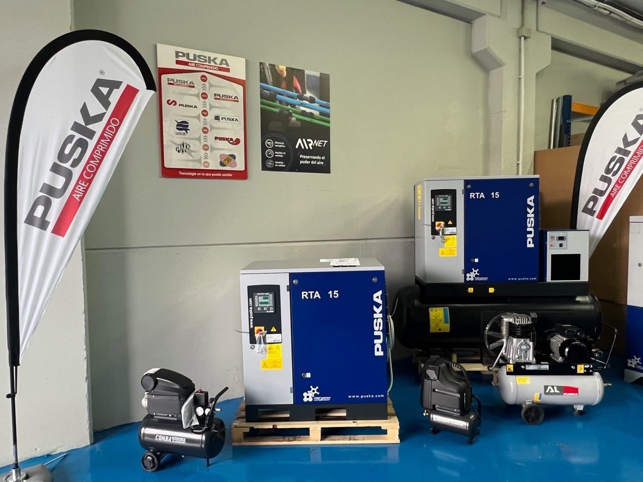 Un grupo de compresores de aire están colocados sobre una paleta en una habitación.